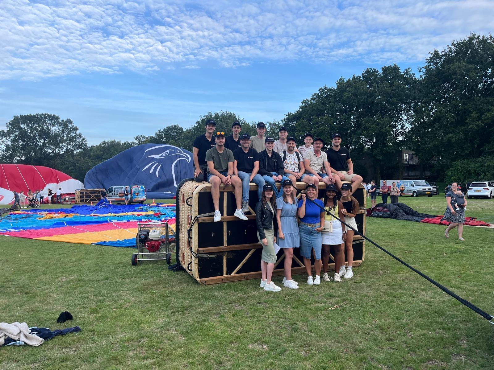 Groep mensen bij het opblazen van luchtballonnen.